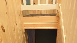 Een smalle houten trap die naar een donkere kamer leidt.