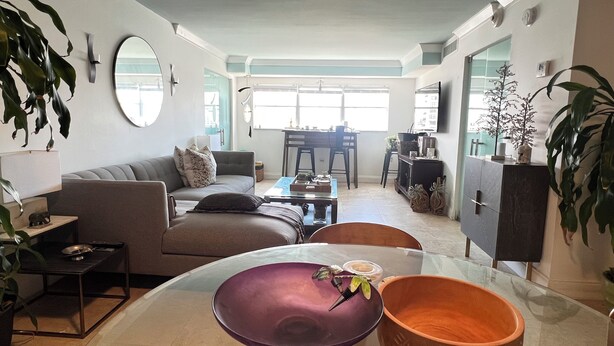 Una sala de estar moderna con sofá, mesa de centro y comedor.
