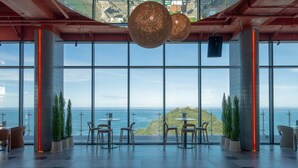 Amplio espacio interior con grandes ventanales que ofrecen vistas al mar y una isla distante.