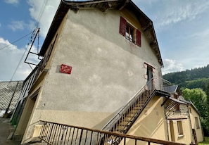 Un edificio con una escalera que conduce a un balcón, un letrero que dice "Villa Michlitz" y un paisaje montañoso al fondo.