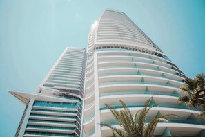 Un edificio alto y moderno con fachada curva y varios balcones.