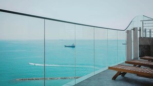 Un balcón con vistas al mar, que incluye un barco y un jet ski.