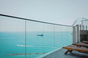 Un balcone con vista sul mare, che include una nave e un jet ski.