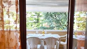 A balcony with a table set for two, chairs, and a bottle of wine. - SG Family - Classic Peschiera (Peschiera del Garda)