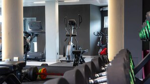 Une salle de sport équipée de machines de cardio, d’haltères et de poids.