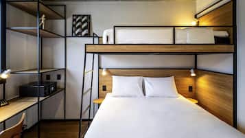 Habitación con literas, escritorio, estanterías y una escalera.