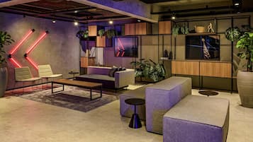 Un área de estar moderna con asientos, una mesa de centro y plantas decorativas.