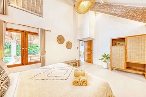 A spacious bedroom with a large bed, a wooden wardrobe, and a view of the outdoors. - Villa Indigo - 5-BDR, huge pool and lush garden (Kecamatan Kuta)