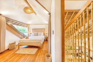 A bedroom with a large bed, a window, and a bamboo railing. - Villa Indigo - 5-BDR, huge pool and lush garden (Kecamatan Kuta)