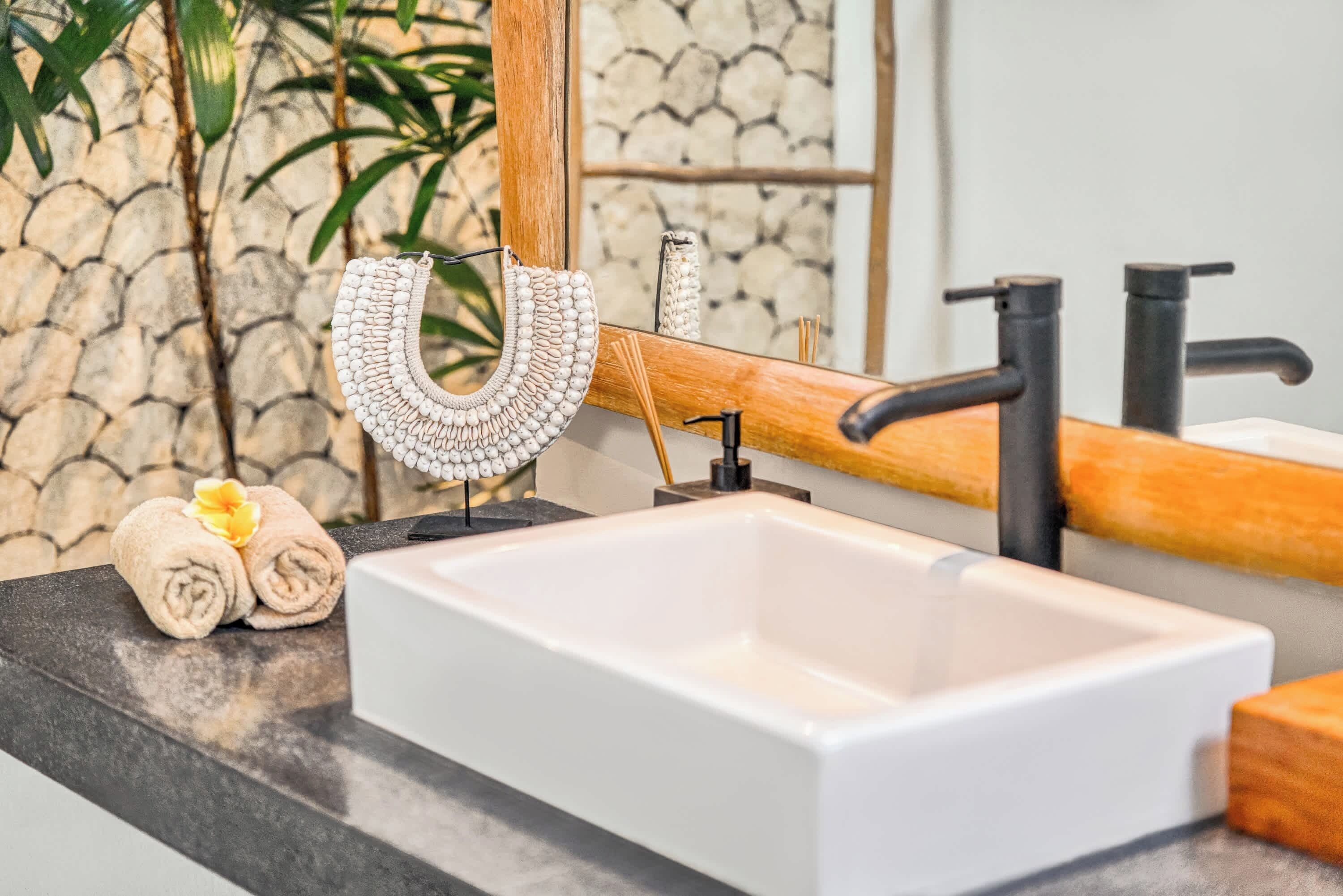 A bathroom with a white sink, black faucet, and a wooden countertop.