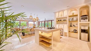 Una cocina moderna con una isla central, estantes empotrados y un refrigerador.