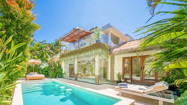 A modern house with a swimming pool, glass walls, and lush greenery. - Villa Florence - 3BDR Luxury Bali Oasis (Kecamatan Kuta Selatan)