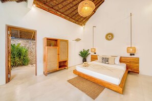 A bedroom with a bed, bedside tables, a wardrobe, a potted plant, and a ceiling fan.