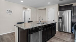A modern kitchen with a granite countertop, stainless steel appliances, and a dishwasher.