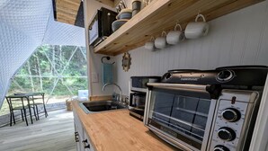Una cocina compacta con un horno Farberware, un lavamanos y una encimera de madera.