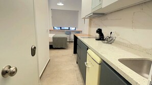 A modern kitchen with a dishwasher, a sink, and a countertop with a coffee maker. - Baélia Experience (Alicante (Alacant))