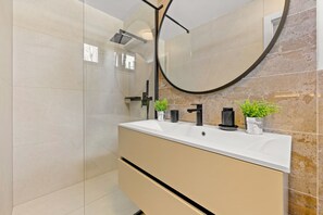 Regadera, secadora de cabello, toallas, papel de baño 