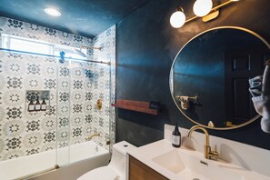 A bathroom with a shower, a sink, and a mirror. - Desert Zen: NEW Heated Pool, Hot Tub, Fire Pit, Game Room, Views & More! (Joshua Tree)