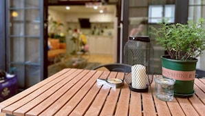 A wooden table with a candle, a glass, and a potted plant. - Shanghai Hills& ZINN city bnb (Shanghai)