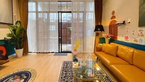 A living room with a yellow sofa, a glass coffee table, and a large window with sheer curtains. - Shanghai Hills& ZINN city bnb (Shanghai)