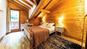 A wooden-paneled bedroom with a bed, bedside tables, and a window. - Chalet Abricotine, sleeps 10, Hot tub (Saint-Jean-d´Aulps)