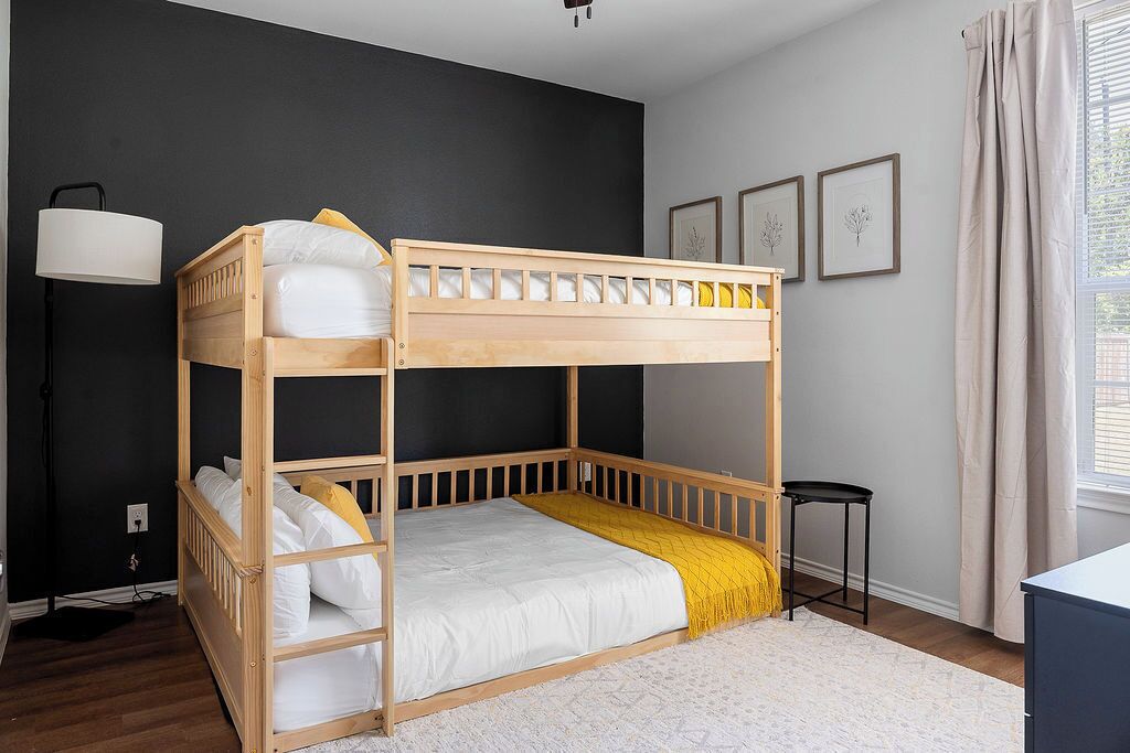 Une chambre avec un lit superposé, un bureau et une lampe.