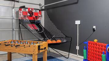 Habitació amb taula de futbolí, cèrcol de bàsquet i cistella de bàsquet.