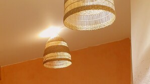A cozy room with a dining table, chairs, a wicker lamp, and a cushioned seating area. - Provencal house with sea view La Croix Valmer "Lou Mamet", ideal for families (La Croix-Valmer)