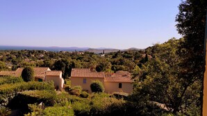 A rural village with terracotta-roofed houses surrounded by lush greenery and a clear view of the sea in the distance. - Provencal house with sea view La Croix Valmer "Lou Mamet", ideal for families (La Croix-Valmer)