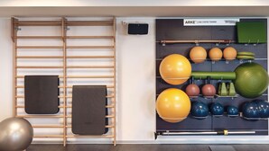 Une salle de sport équipée de matériel d’exercice, notamment une barre de traction, des balles lestées et un tapis de yoga.