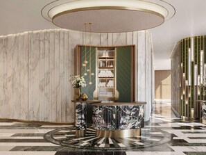 Eine Lobby mit einem Marmor-Rezeptionsschalter, einer grünen Akzentwand und einem gemusterten Boden.