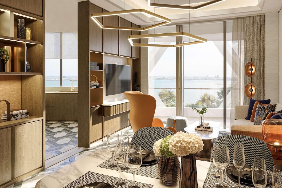Un salon moderne doté d’un grand téléviseur, d’un coin repas avec une table dressée pour quatre personnes, et offrant une vue sur la ville grâce à de grandes fenêtres.