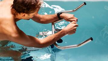 Uma pessoa segurando uma estrutura de metal em uma piscina.
