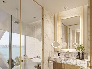 Une salle de bain moderne dotée d’un grand miroir, d’un plan de toilette en marbre et offrant une vue sur la ville grâce à une porte en verre.