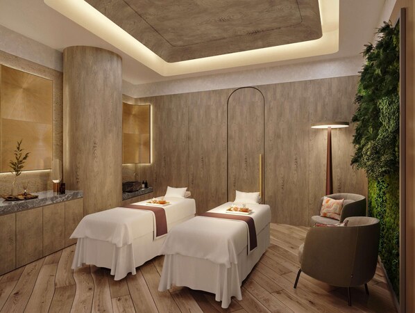 A modern hotel room with two beds, a sitting area, a large mirror, a wooden floor, and a green wall feature. - Swissôtel Residences Corniche Park Towers (Doha)