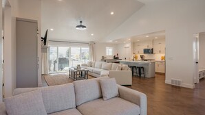 A spacious living area with a sofa, a coffee table, and a kitchen in the background. - Lakeview Lodge - Lakeside Escape (Scofield)