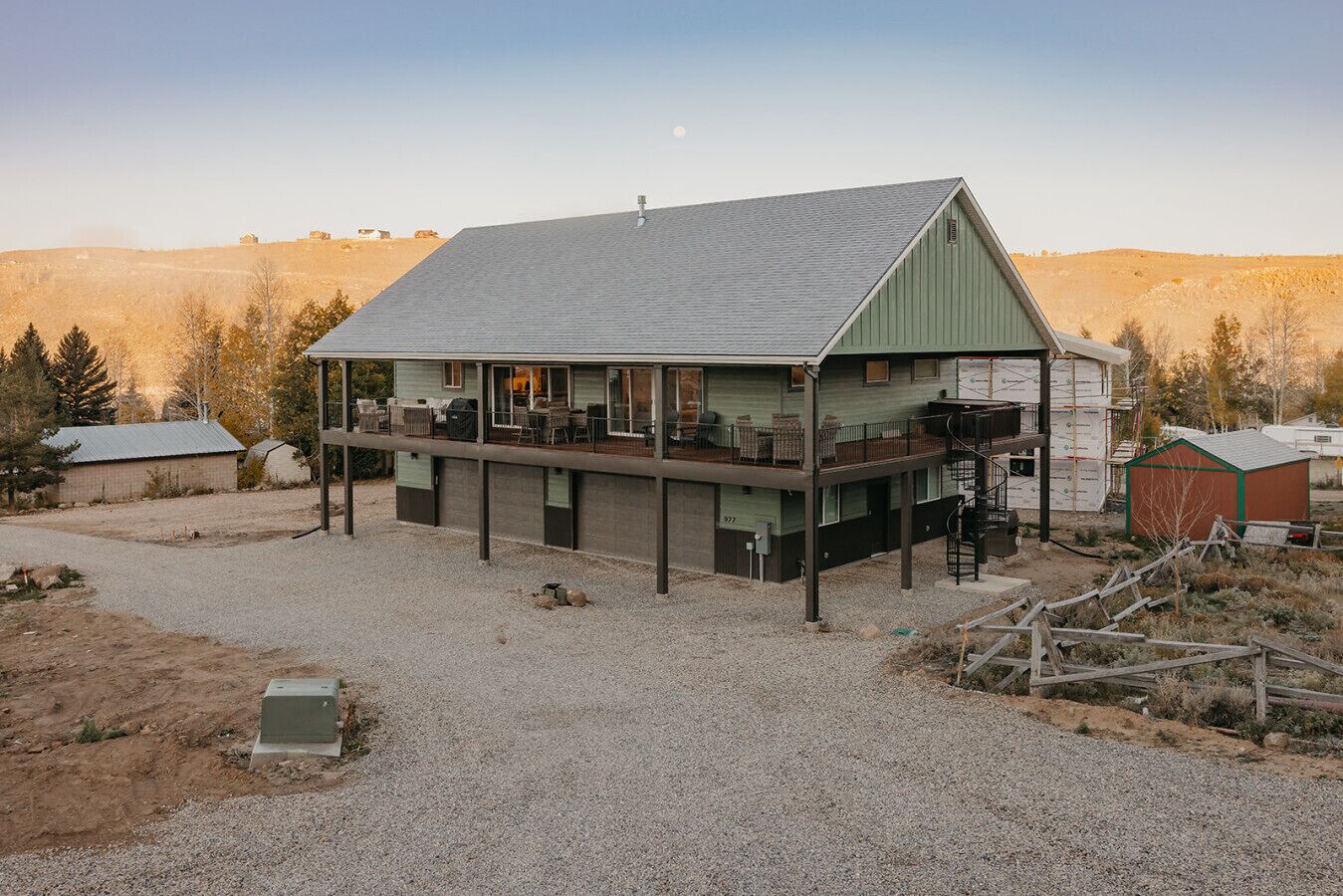 A two-story building with a covered porch and a small attached shed.