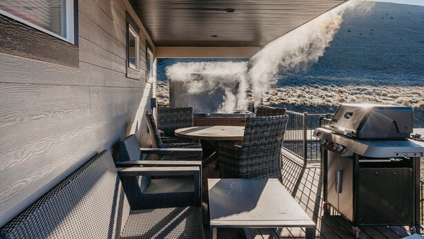 An outdoor patio with a grill and seating area, overlooking a mountainous landscape. - Mountain View Lodge - Spacious Cabin Retreat with Hot Tub, (Scofield)