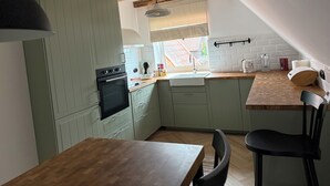 A kitchen with a wooden table, a sink, and a stove.