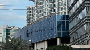 A modern multi-story building with balconies, large windows, and a glass facade.