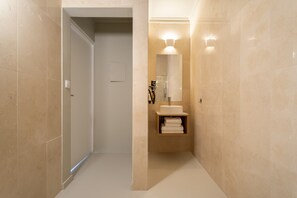 Ein modernes Badezimmer mit Waschtisch, Spiegel und Handtuchhalter.