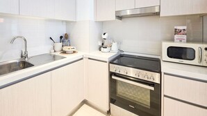Una cocina moderna con electrodomésticos de acero inoxidable, un microondas y un horno empotrado.