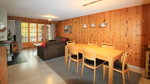 A wooden-paneled room with a dining table, chairs, a sofa, and a fireplace. - Veisivis 74  Tout confort  piscine  La Forclaz (La Forclaz)