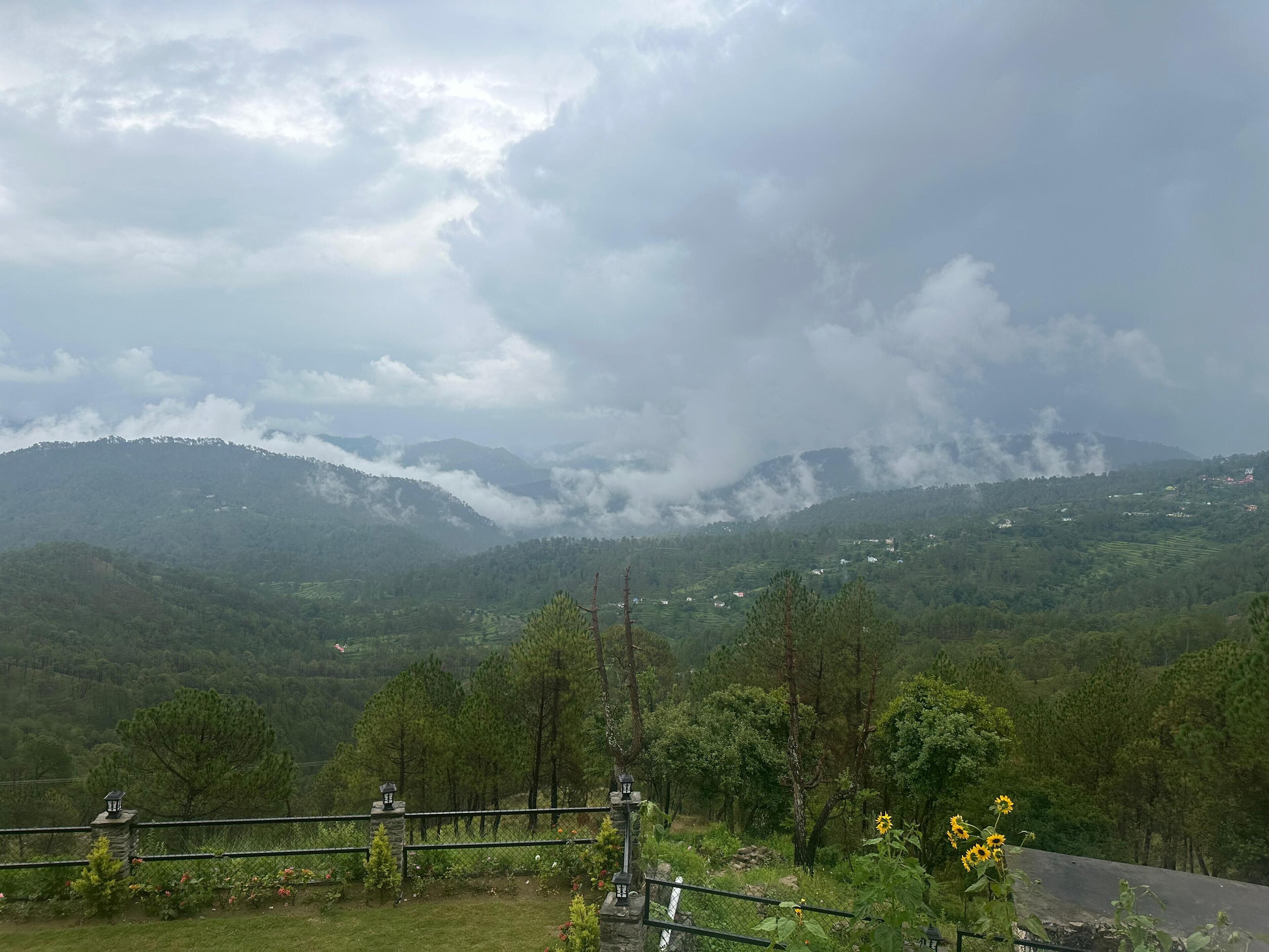 A mountainous landscape with a view of distant hills and a cloudy sky.