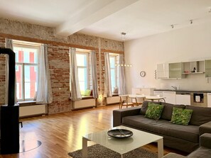 Un salon moderne avec un canapé, une table basse et un coin repas.