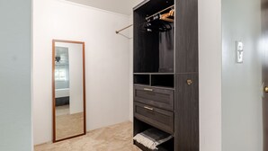 Una habitación con un armario de madera oscura, un espejo y una puerta.
