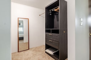Una stanza con un'armadiatura in legno scuro, uno specchio e una porta.