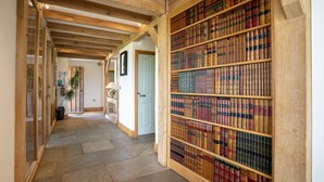 Un couloir avec des poutres en bois et une bibliothèque remplie de livres.