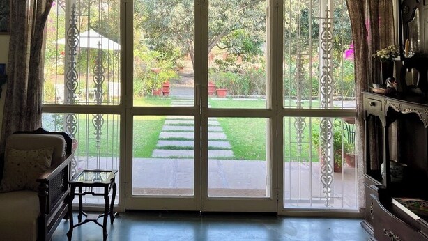Ein Zimmer mit einer großen Glastür, die zu einem Garten führt.
