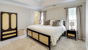 A bedroom with a bed, a nightstand, a ceiling fan, a wardrobe, and a window with curtains. - Playroom & Home Office: Family Retreat in Mauldin! (Mauldin)